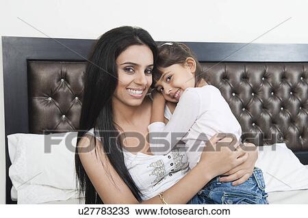 Portrait of a woman hugging her daughter View Large Photo Image Stock Image - Portrait of a woman hugging her daughter. Fotosearch