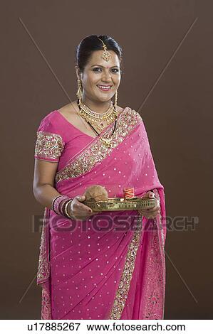 Stock Photo - Portrait of a woman in sari holding religious offering. Fotosearch