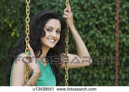 Stock Image - Portrait of a woman on a swing. Fotosearch