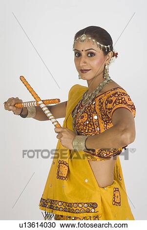 Stock Image - Portrait of a woman performing dandiya. Fotosearch