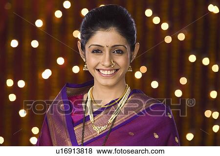 Portrait of a woman smiling in front of Diwali decoration View Large Photo Image Stock Photo - Portrait of a woman smiling in front of Diwali decoration. Fotosearch