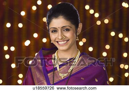 Portrait of a woman smiling in front of Diwali decoration View Large Photo Image Stock Photograph - Portrait of a woman smiling in front of Diwali decoration. Fotosearch