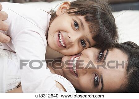 Portrait of a woman smiling with her daughter View Large Photo Image Stock Image - Portrait of a woman smiling with her daughter. Fotosearch