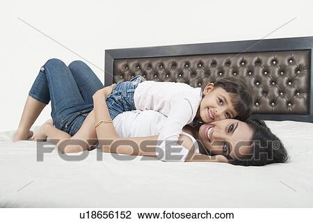 Portrait of a woman smiling with her daughter View Large Photo Image Stock Image - Portrait of a woman smiling with her daughter. Fotosearch