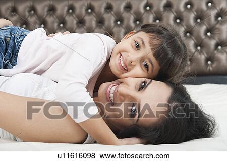 Portrait of a woman smiling with her daughter View Large Photo Image Stock Photo - Portrait of a woman smiling with her daughter. Fotosearch