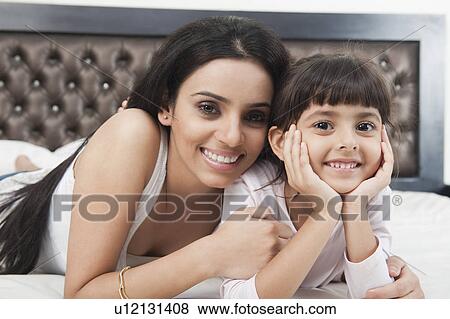 Portrait of a woman smiling with her daughter View Large Photo Image Stock Photo - Portrait of a woman smiling with her daughter. Fotosearch