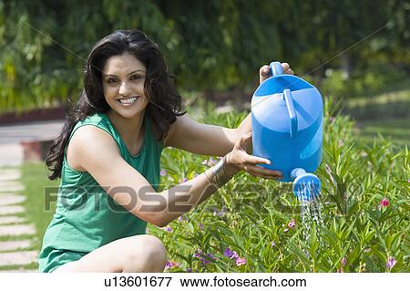 Portrait of a woman watering plants View Large Photo Image Stock Photo - Portrait of a woman watering plants. Fotosearch