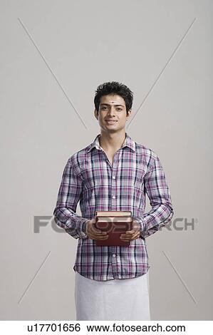 Portrait of an university student holding books View Large Photo Image Stock Photograph - Portrait of an university student holding books. Fotosearch