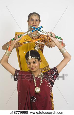 Portrait of two women performing dandiya View Large Photo Image Stock Photo - Portrait of two women performing dandiya. Fotosearch