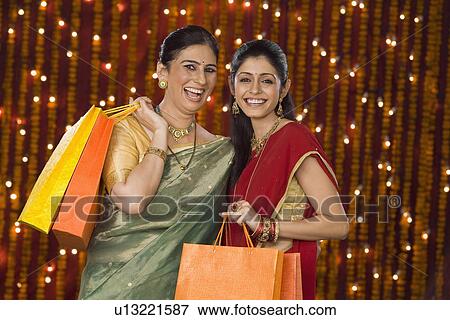 Portrait of women holding shopping bags and smiling View Large Photo Image Stock Photo - Portrait of women holding shopping bags and smiling. Fotosearch