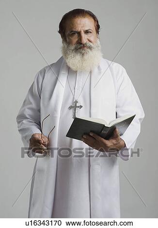 Priest holding a holy book View Large Photo Image Stock Image - Priest holding a holy book. Fotosearch