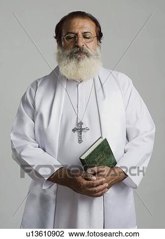 Stock Image - Priest praying. Fotosearch