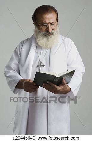 Priest reading a holy book View Large Photo Image Stock Image - Priest reading a holy book. Fotosearch