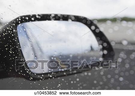 Stock Image - Rain drops on the side-view mirror of a car, Dublin, Republic of Ireland. Fotosearch