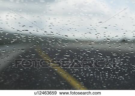 Stock Photo - Rain drops on the windshield of a car, Dublin, Republic of Ireland. Fotosearch