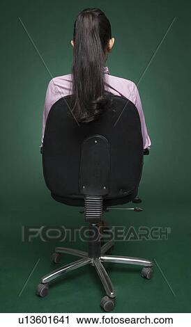 Rear view of a businesswoman sitting on a chair View Large Photo Image Stock Image - Rear view of a businesswoman sitting on a chair. Fotosearch