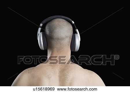 Stock Photo - Rear view of a man listening to headphones. Fotosearch