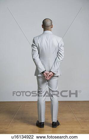 Rear view of a man standing View Large Photo Image Stock Image - Rear view of a man standing. Fotosearch
