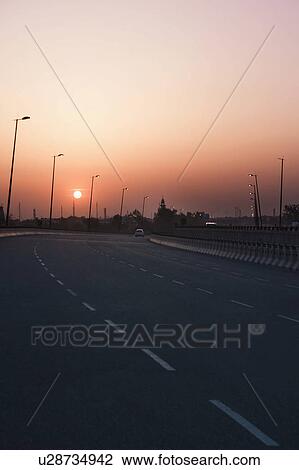 Stock Image - Road at sunset, National Highway 8, Gurgaon, Haryana. Fotosearch