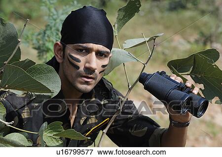 Soldier holding binoculars in a forest View Large Photo Image Stock Photo - Soldier holding binoculars in a forest. Fotosearch