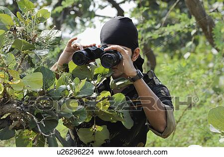 Soldier looking through binoculars in a forest View Large Photo Image Picture - Soldier looking through binoculars in a forest. Fotosearch