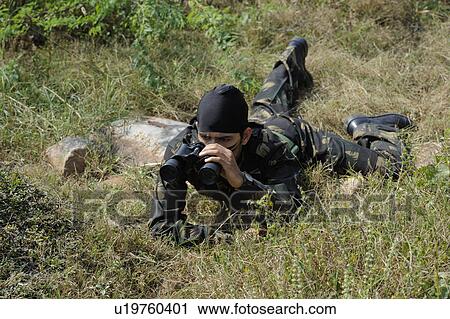 Soldier looking through binoculars in a forest View Large Photo Image Stock Image - Soldier looking through binoculars in a forest. Fotosearch