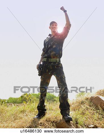 Soldier standing in a field celebrating his success View Large Photo Image Stock Image - Soldier standing in a field celebrating his success. Fotosearch