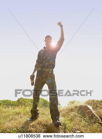 Soldier standing in a field celebrating his success View Large Photo Image Stock Photo - Soldier standing in a field celebrating his success. Fotosearch