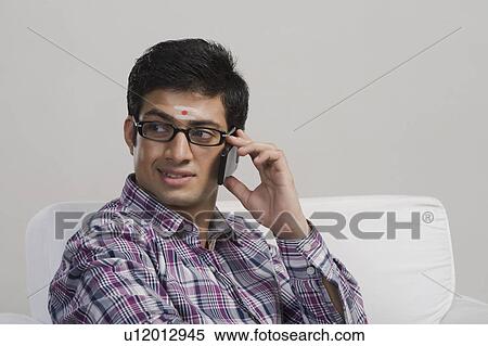 South Indian man talking on a mobile phone View Large Photo Image Stock Photography - South Indian man talking on a mobile phone. Fotosearch
