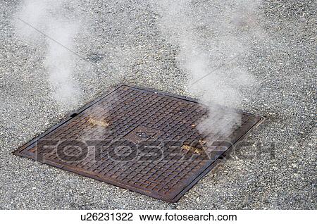 Stock Image - Steam emerging from a manhole of a brewery, Eggenberg, Cesky Krumlov, South Bohemian Region, Czech Republic. Fotosearch