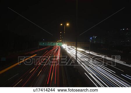 Picture - Streaks of lights of moving vehicles on the road, National Highway 8, Gurgaon, Haryana, India. Fotosearch
