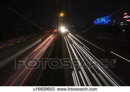 Stock Image - Streaks of lights of moving vehicles on the road, National Highway 8, Gurgaon, Haryana, India. Fotosearch