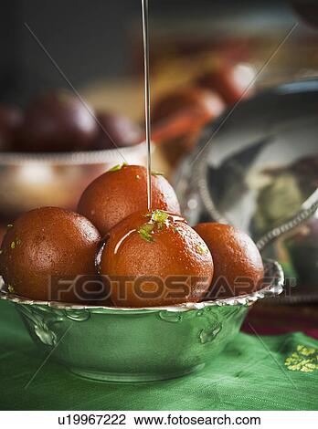 Sugar syrup being poured on gulab jamuns in a bowl View Large Photo Image Stock Image - Sugar syrup being poured on gulab jamuns in a bowl. Fotosearch