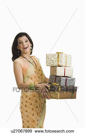 Stock Photo - Surprised woman holding gifts at Diwali festival. Fotosearch