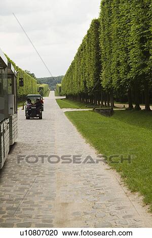 Stock Image - Tourists in a golf cart, Chateau de Versailles, Versailles, Paris, France. Fotosearch