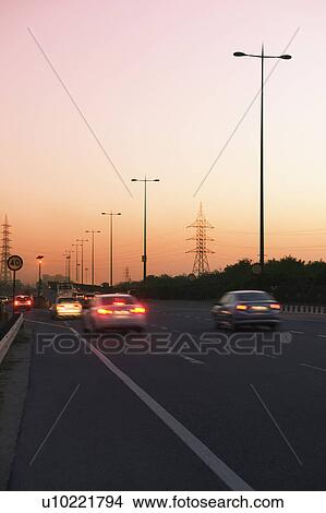 Picture - Traffic on a highway at dusk, National Highway 8, Gurgaon, Haryana, India. Fotosearch