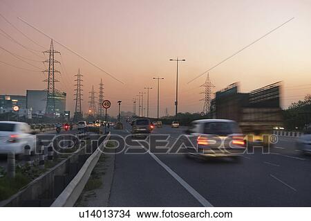 Picture - Traffic on a highway at dusk, National Highway 8, Gurgaon, Haryana, India. Fotosearch