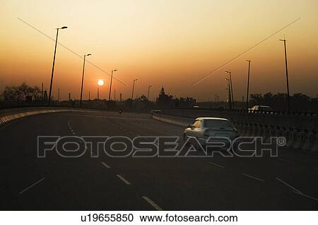 Stock Image - Traffic on a highway at dusk, National Highway 8, Gurgaon, Haryana, India. Fotosearch
