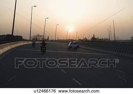 Stock Photograph - Traffic on a highway at dusk, National Highway 8, Gurgaon, Haryana, India. Fotosearch