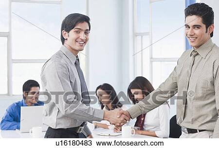 Stock Image - Two businessmen shaking hands. Fotosearch