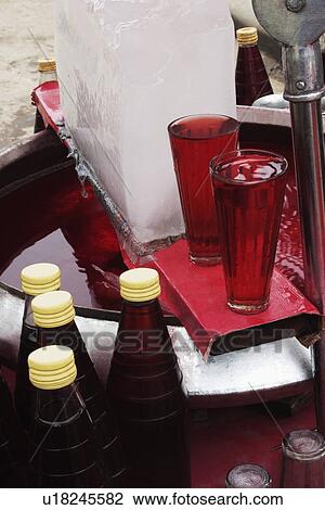 Stock Image - Two glasses of drink at a market stall, New Delhi, India. Fotosearch
