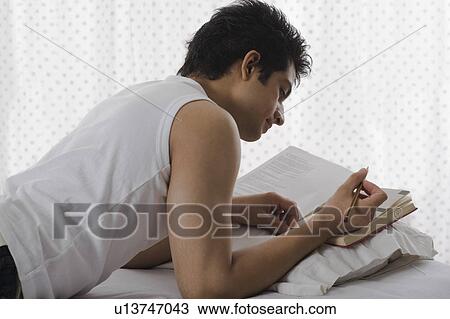 University student reading a book on the bed View Large Photo Image Stock Image - University student reading a book on the bed. Fotosearch