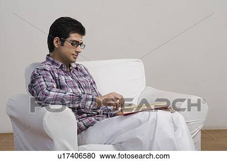 Stock Image - University student reading a book. Fotosearch