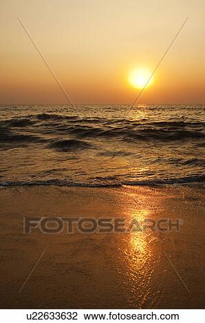 Stock Image - Waves on the beach at sunset, Goa, India. Fotosearch