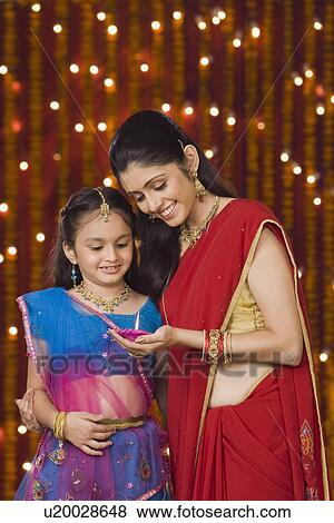 Woman and daughter holding oil lamp and smiling View Large Photo Image Stock Photo - Woman and daughter holding oil lamp and smiling. Fotosearch