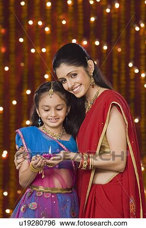Woman and daughter holding oil lamp and smiling View Large Photo Image Stock Photograph - Woman and daughter holding oil lamp and smiling. Fotosearch