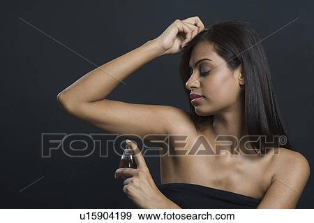 Woman applying perfume View Large Photo Image Stock Photo - Woman applying perfume. Fotosearch