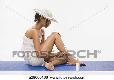 Stock Photograph - Woman applying suntan lotion. Fotosearch