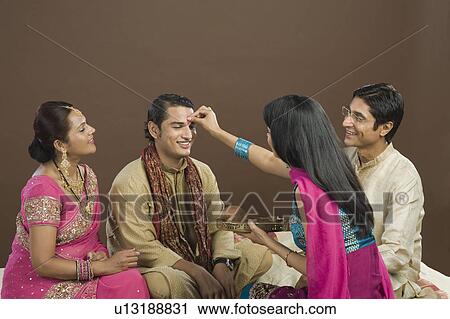 Woman applying tilak on her brother's forehead at Raksha Bandhan festival View Large Photo Image Stock Image - Woman applying tilak on her brother's forehead at Raksha Bandhan festival. Fotosearch