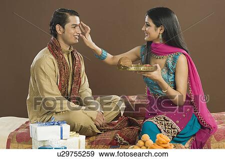 Woman applying tilak on her brother's forehead at Raksha Bandhan festival View Large Photo Image Stock Photo - Woman applying tilak on her brother's forehead at Raksha Bandhan festival. Fotosearch